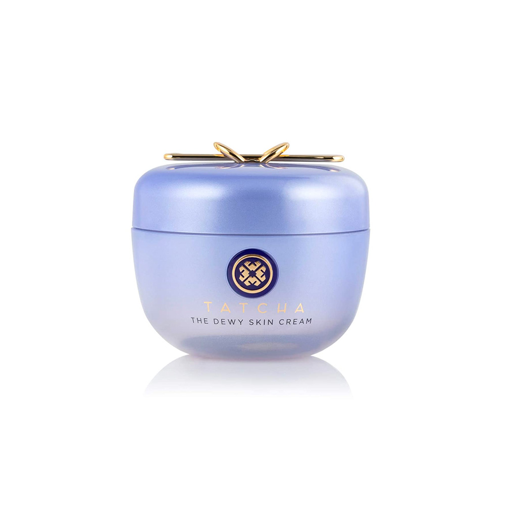 blueish purple cream container with gold hardware on top and a label at the front