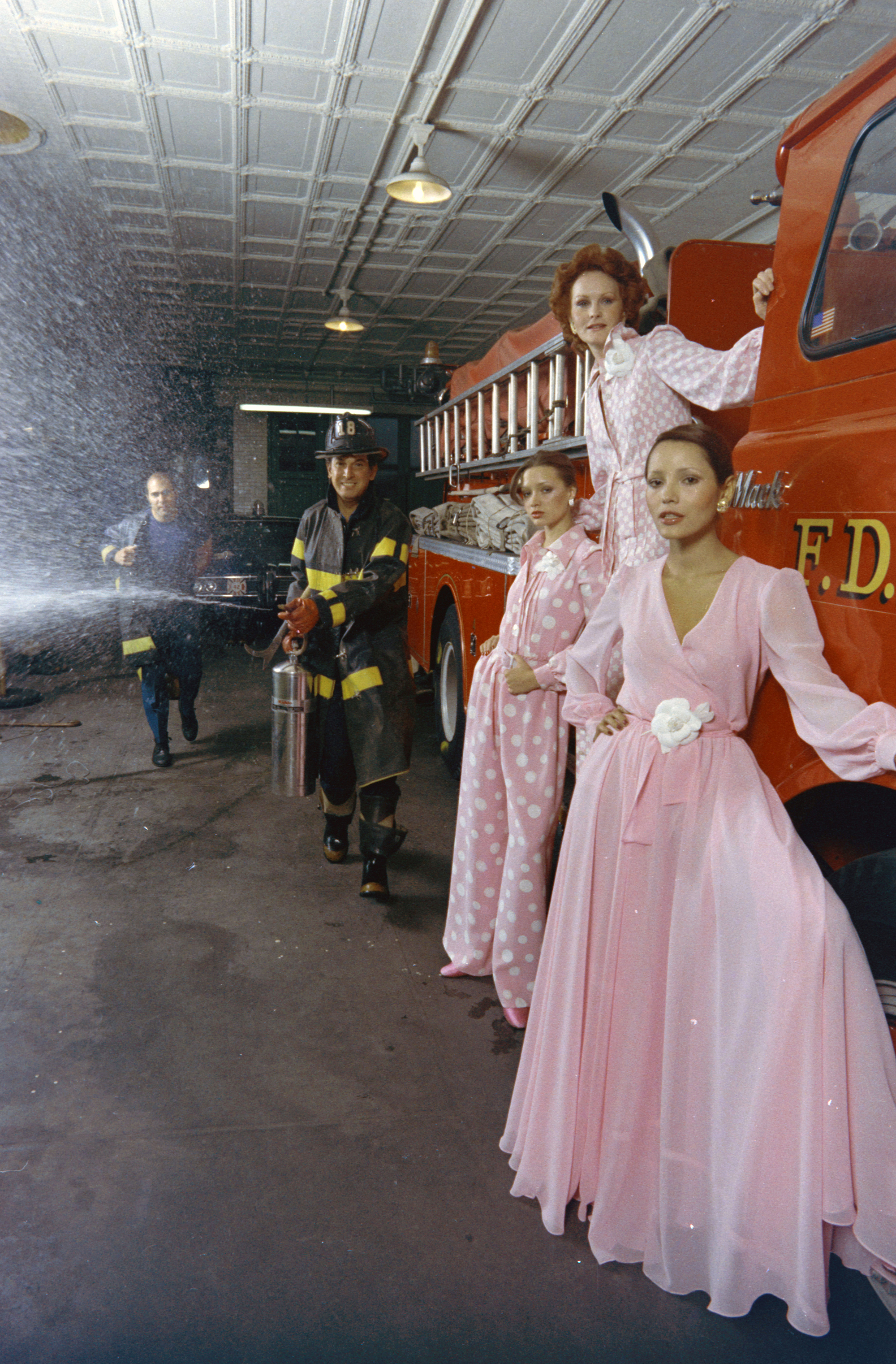 Designer Oscar de la Renta, models and members of New York Fire Department, Engine 18. Model Barbara Carrera.