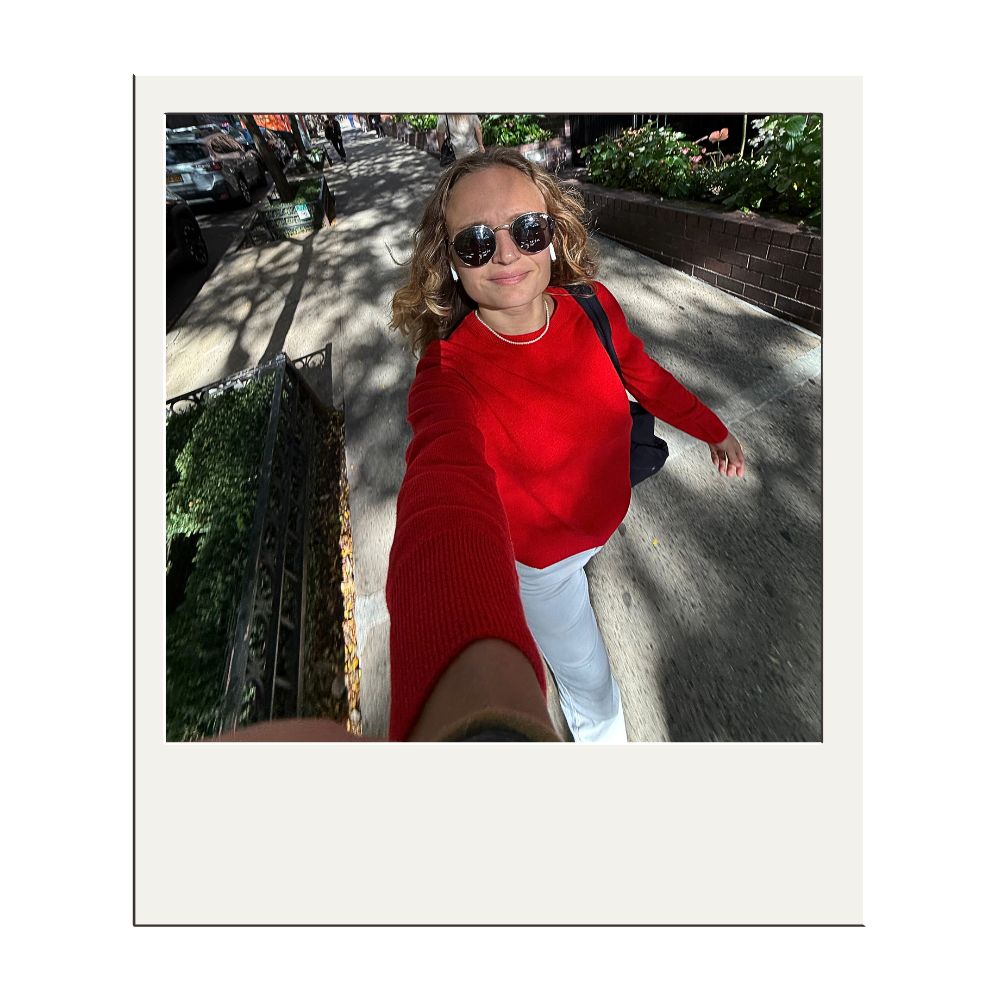 author wearing the bright red version of naadam's original sweater out on a new york city street